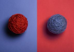 Red ball of yarn on a blue background; blue ball of yarn on a red background